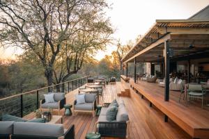 a wooden deck with couches and chairs on it at Thornybush Simbambili Lodge in Sabi Sand Game Reserve