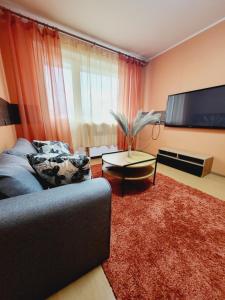 a living room with a couch and a flat screen tv at Harku Lake Apartment in Tallinn