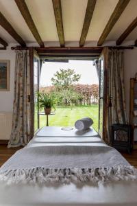 a bedroom with a bed and a large window at The Hideaway-South Downs National Park in Graffham