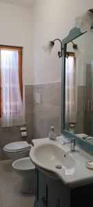 a bathroom with a sink and a toilet and a mirror at Sa domo manna in Porto Ottiolu +70 photos