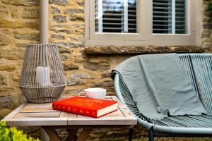 a wooden table with two books and a vase on it at Gable Cottage in Meysey Hampton