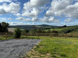 un campo con recinzione e verdi colline di Sky High Glamping a Shillelagh Altre 9 foto