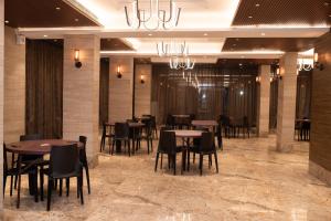 a dining room with tables and chairs and a chandelier at NK7 Hotel in Kolkata