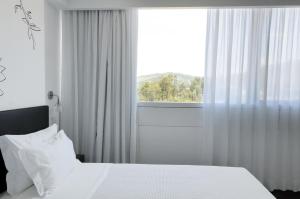 Cama ou camas em um quarto em Open Village Sports Hotel & Spa Club