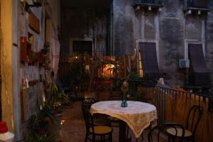 a table and chairs in a room with a balcony at Casa Verdi - House of Travelers in Catania