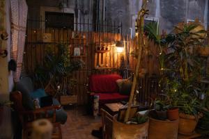 a living room filled with lots of plants and a red couch at Casa Verdi - House of Travelers in Catania