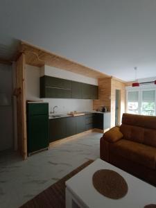 a living room with a couch and a kitchen at A Porta Verde in O Grove