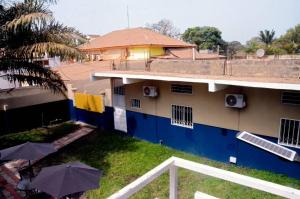 a building with umbrellas in the grass in front of it at One Bedroom Apartment SS7-MUHAMMED in Kololi