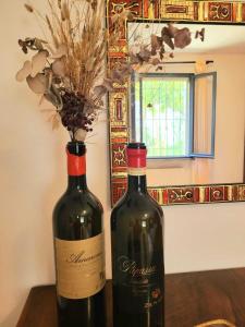 - deux bouteilles de vin assises au-dessus d'une table dans l'établissement Casa Pascoli, à Ravenne