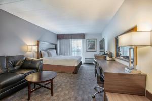 a hotel room with a bed and a couch at Days Inn by Wyndham Sudbury & Conference Centre in Sudbury +80 photos