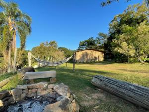 a park with a hammock and a bench in a field at Refúgio Pauapique - Suítes com café da manhã, ar condicionado e frigobar à 900 metros da Rota do Vinho in São Roque