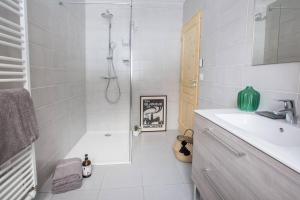 a white bathroom with a shower and a sink at Chalet Renard Fou -Luxury 2 Bedroom Apartment in Morzine +13 photos