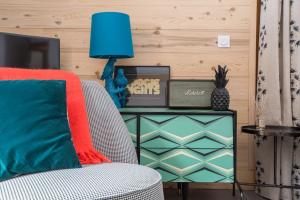 a living room with a chair and a blue lamp at Chalet Renard Fou -Luxury 2 Bedroom Apartment in Morzine