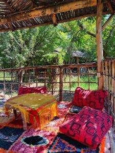 a room with a table and two chairs on a rug at Dar TOUFTEN in Agouni +22 photos