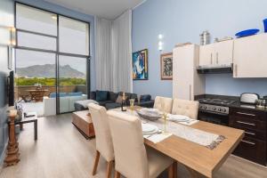 Una cocina y una sala de estar con mesa y sillas. en Apartment near Hout Bay Harbour, en Ciudad del Cabo