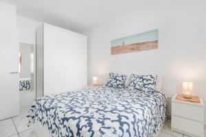 プエルト・デル・カルメンにあるVistamarの白いベッドルーム(ベッド1台、ランプ2つ付)