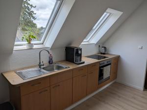 a kitchen with a sink and a stove and a window at Dachgeschoss Wohnung nahe Heide in Tostedt