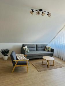 诺德代希Casa del Sol - Ferienwohnung Norddeich的客厅里有一张蓝色的沙发和一张桌子