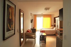 Sala de estar con dormitorio con cama y espejo en Miliño Apart Hotel en Buenos Aires