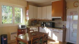 a kitchen with white cabinets and a table with chairs at Marie-Pierre in Ciboure