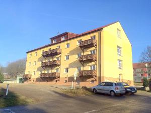 a yellow building with a car parked in front of it at Apartmány Jakub - Lipno nad Vltavou in Lipno nad Vltavou