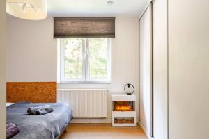 a bedroom with a bed and a fireplace at Apartament Gdańsk Park Śródmieście in Sidlice