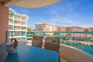 a balcony with a table and chairs and a swimming pool at Un Air De Venise in Fréjus +11 photos