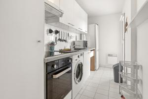 a white kitchen with a washer and dryer in it at Un Air De Venise in Fréjus