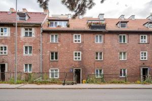 a large red brick building with a courtyard at Apartament Gdańsk Park Śródmieście in Sidlice
