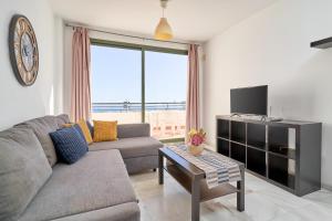 een woonkamer met een bank en een tv bij Apartamento Balcon De Nerja I in Nerja