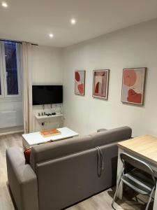 a living room with a couch and a television at Gold, 500 m du centre de Valence in Bourg-lès-Valence
