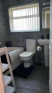 a bathroom with a toilet and a tub and a sink at Stylish 3 bedroom house in Whitchurch +20 photos