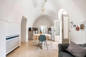 ein Wohnzimmer mit Tisch und Couch in der Unterkunft Trullo Oasi Santo Stefano - private pool in Castellana Grotte + 44 Fotos