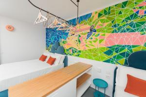a bedroom with a colorful mural on the wall at Albergo Dipinto BaccoFurore in Furore