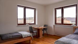 une chambre avec une table, un lit et des fenêtres dans l'établissement Golf und Thermen Ferienhaus Golfblick Bad Loipersdorf, à Gillersdorf