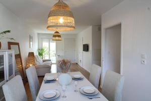 ein Esszimmer und ein Wohnzimmer mit Tisch und Stühlen in der Unterkunft Charmante maison avec piscine in Puilboreau