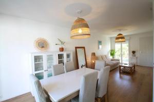 ein Esszimmer und ein Wohnzimmer mit einem weißen Tisch und Stühlen in der Unterkunft Charmante maison avec piscine in Puilboreau + 17 Fotos