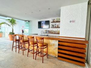 un bar con una fila di sgabelli in legno di Casa Mexicana Cozumel a Cozumel