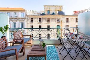 a balcony with chairs and a table and a building at L53 1BR Hotel des Postes, Place Massena Terrace & AC in Nice