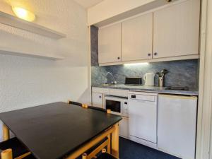 kuchnia z białymi szafkami i czarnym blatem w obiekcie Studio lumineux près des pistes avec balcon, 4 pers - FR-1-425-163 w mieście Flaine +5 zdjęć