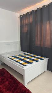 Cama en habitación con cortina negra en Naimz short stay Apartment, en Abu Dabi