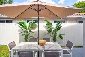 a white table with an umbrella in a yard at Luxury Home in Brickell Miami, 5 min to the Beach! in Miami