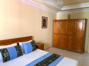 Un dormitorio con una cama y un armario de madera. en Abdallah Appartement, en Essaouira