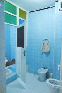Un baño azul con inodoro y lavabo. en Abdallah Appartement, en Essaouira 11 fotos más