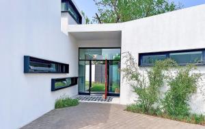 a white house with a red door andwindows at 4 Lulworth in Johannesburg