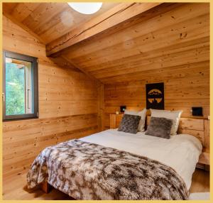 Un dormitorio con una cama en una cabaña de madera. en Le Grand Condor I Duplex I Morzine, en Morzine