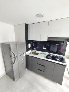 una cucina con frigorifero in acciaio inox e lavello di apartamento en Bogotá cerca a embajada americana, universidad nacional y centro historico a Bogotá