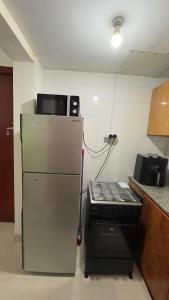 una cocina con refrigerador y estufa en Naimz short stay Apartment, en Abu Dabi