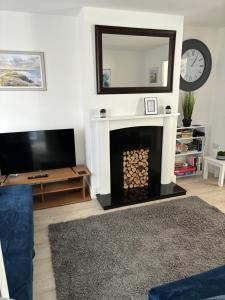 a living room with a fireplace and a mirror at Stylish 3 bedroom house in Whitchurch
