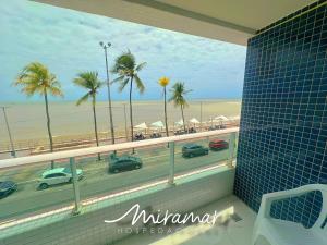 a balcony with a view of the beach and palm trees at Blue Premium em Cabo Branco Beira Mar in João Pessoa